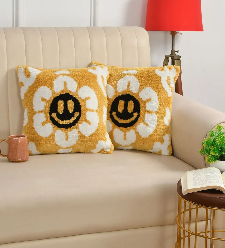 Two yellow pillows with smiley face patterns on a beige couch.