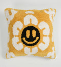 Decorative pillow with a smiley face design on a yellow background