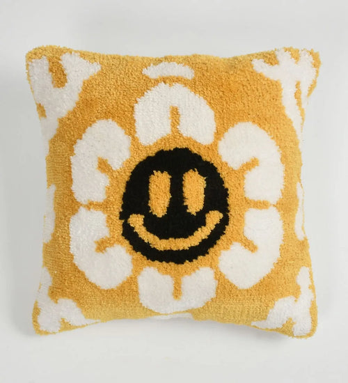 Decorative pillow with a smiley face design on a yellow background